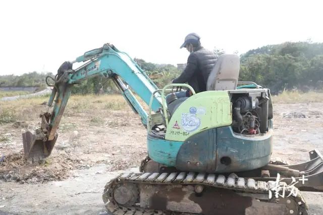 第四社区文明路挖掘机在挖坑作业,为植树绿化做好准备。 图片